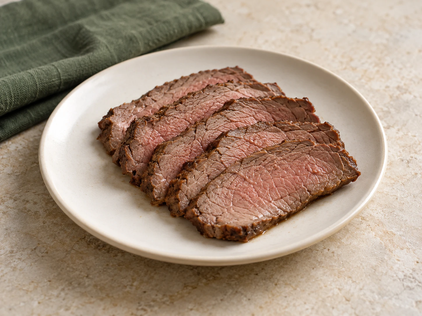 Slices of cooked roast beef on a small ceramic plate.